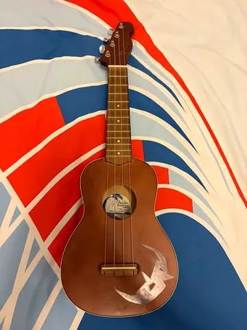 Used soprano/tenor ukulele with wooden finish and moon decal