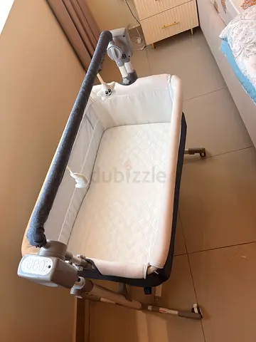 Portable bedside bassinet with adjustable height and soothing features