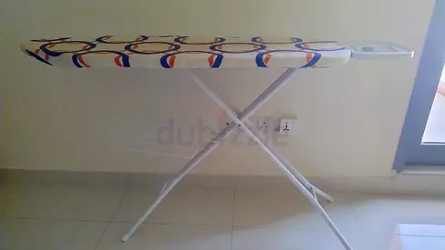 Folding metal-frame ironing board with an integrated iron rest and a patterned fabric cover