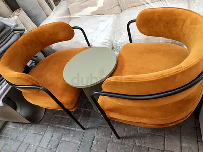 Pair of mustard velvet lounge chairs with small round side table