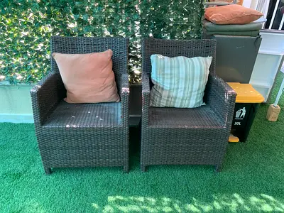 Pair of outdoor rattan armchairs with cushions