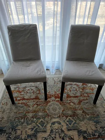 Pair of modern grey upholstered dining chairs with wooden legs