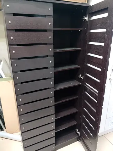 Tall dark wood multi-shelf cabinet — good for shoes or toys