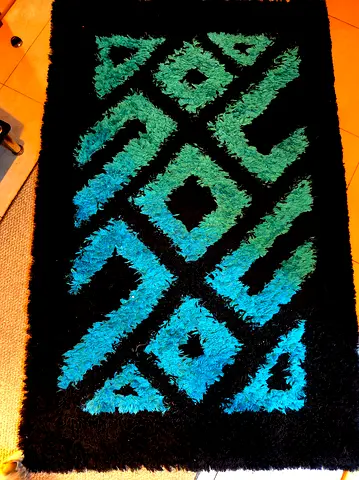 Black shaggy rug with teal geometric pattern - good condition