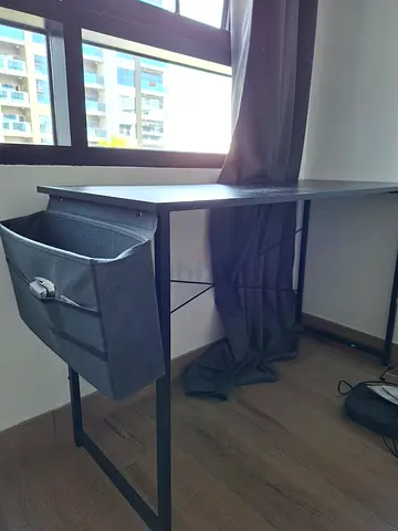 Simple black metal frame desk with grey storage ottoman