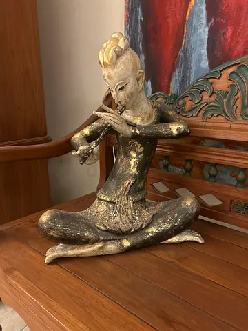 Thai flautist statue, seated.
