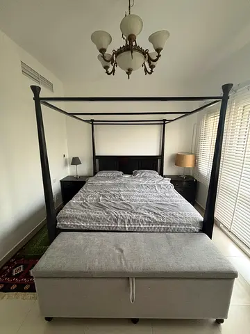 King four-poster canopy bed with bedside tables and storage bench and chairs