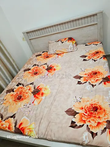 Queen bed with wooden headboard and floral bedding set