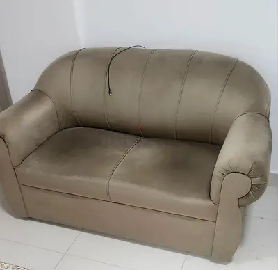 Two-seater beige fabric sofa in good used condition