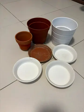 Assorted plastic plant pots and saucers - set of 7