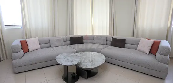 Light grey curved sectional sofa in good condition