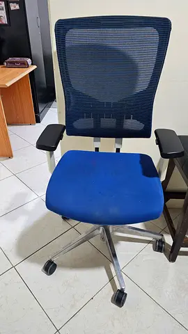 Used ergonomic office chair with mesh back and blue seat