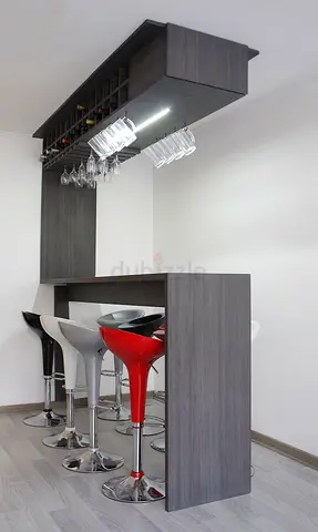 Modern grey wooden home bar with overheard rack and stools
