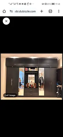 Large dark wood built-in wardrobe with mirrors and storage.