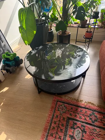 Round glass-top coffee table with black metal frame, good condition - 88cm diameter