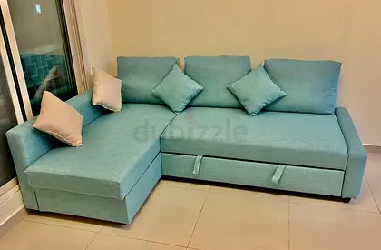 Light teal L-shaped sectional sofa with storage and pull-out bed