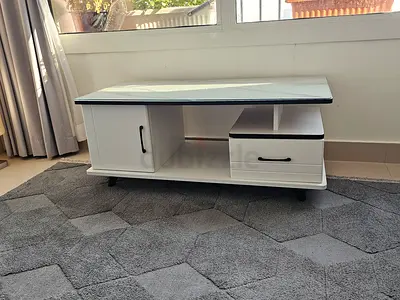 White modern TV/entertainment unit with glass top and storage/ coffe table
