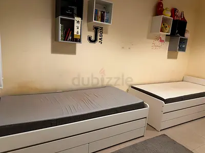 Pair of white single trundle beds with mattresses - good condition