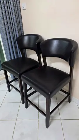 Set of 2 black counter-height bar stools with padded seats and backs