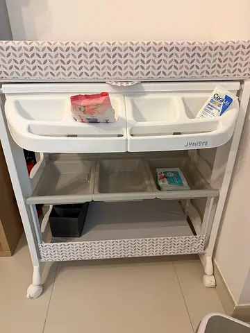 White baby changing table with storage bins