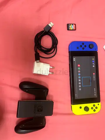 Nintendo Switch OLED (Neon Blue/Yellow Joy‑Cons) with dock grip, charger and sport cart game