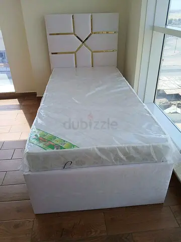 Single white bed with headboard and mattress -
