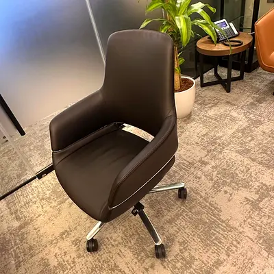 Black leather swivel office chair with armrests and casters