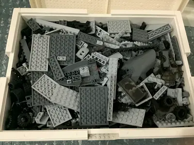 Large lego box containing many sorted black and grey bricks