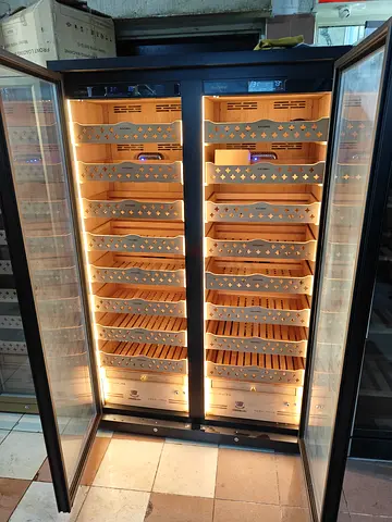 Reaching Premium Double-Door Humidor Cabinet with spacious wooden cigar storage shelves, warm interi