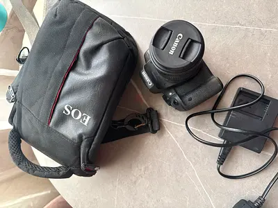 Canon EOS DSLR with 18-55mm kit lens, charger and carrying bag
