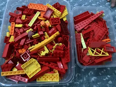 2 lego boxes filled with red, yellow and orange bricks