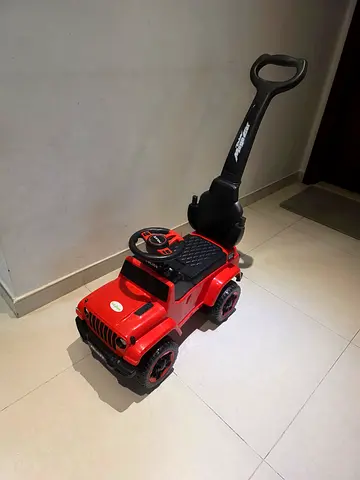 Red ride-on push car with parental handle — good condition