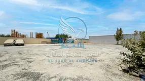 Yard for rent in Al Sajaa, 20,000 sq. ft., with 60 kW electricity, suitable for commercial and indus