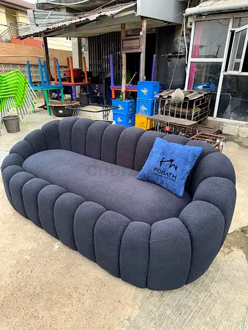 Modern Grey Curved Ribbed Sofa with Blue Throw Pillow