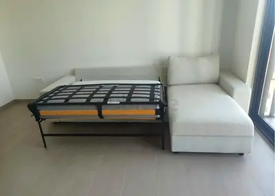 Light grey L-shaped sofa with pull-out bed - good condition