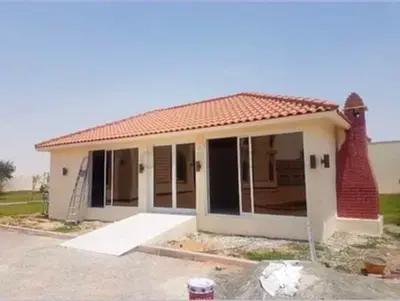 Small prefab garden house with tiled roof and large glass doors