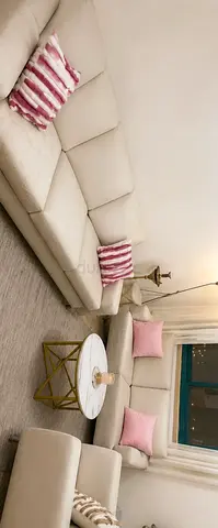 Light beige L-shaped sectional sofa with pink cushions