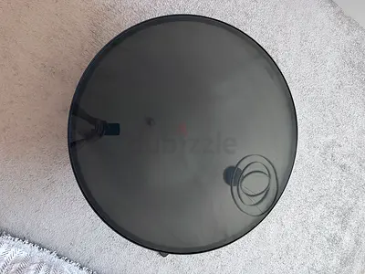 Round smoked glass side table with black frame - good condition