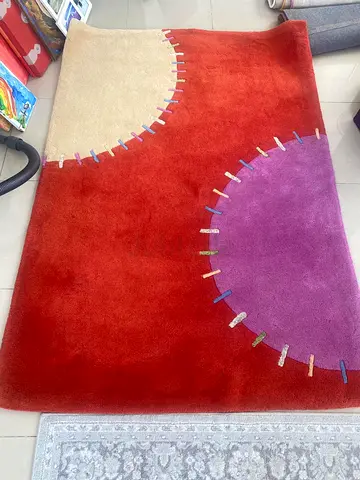 Red modern area rug with circular cream and purple accents - Good condition