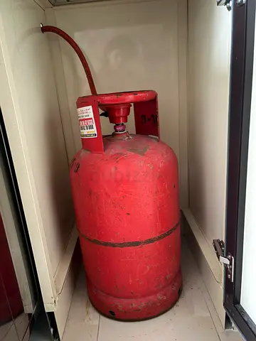 Gas cylinder (15.9) with regulator and hose