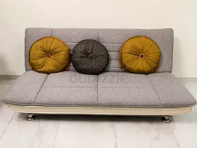 Grey fabric sofa bed with round cushions - good condition
