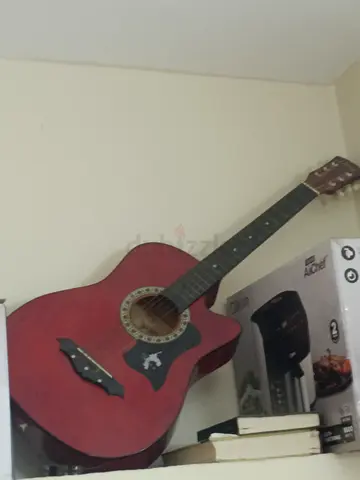 Red acoustic guitar with cutaway - used