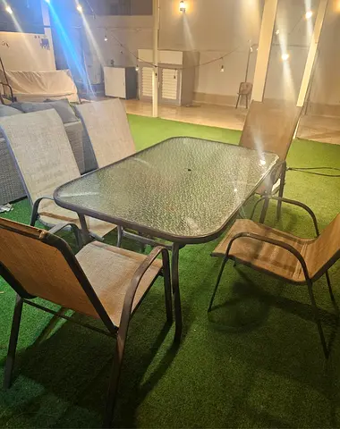 Outdoor glass-top dining table with 5 sling chairs - good condition