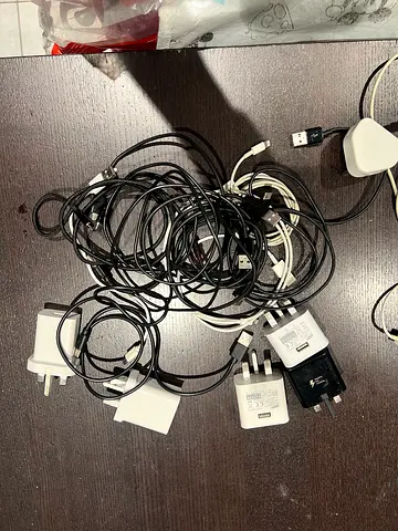 Bundle of mixed phone chargers and USB cables, used