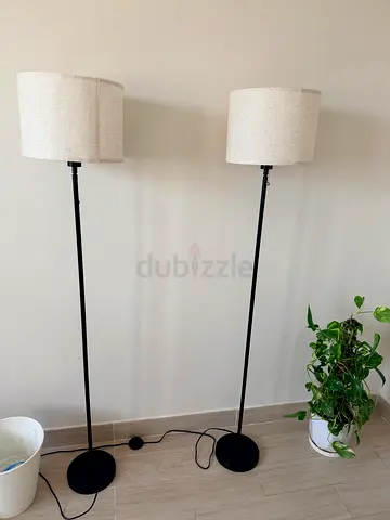 Pair of black metal floor lamps with beige fabric shades
