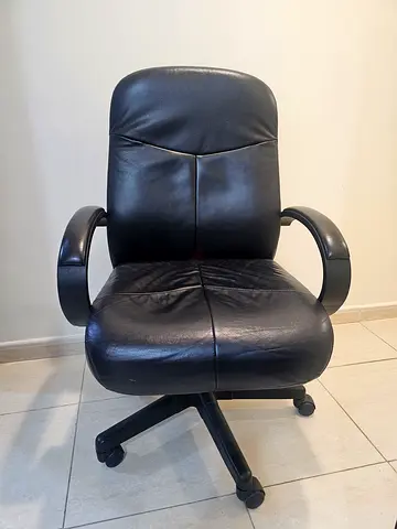 Black leather swivel office chair and office desk
