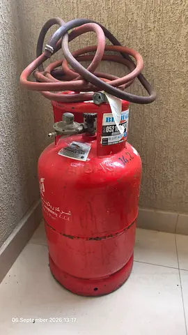 Used red LPG gas cylinder with hose - good working condition