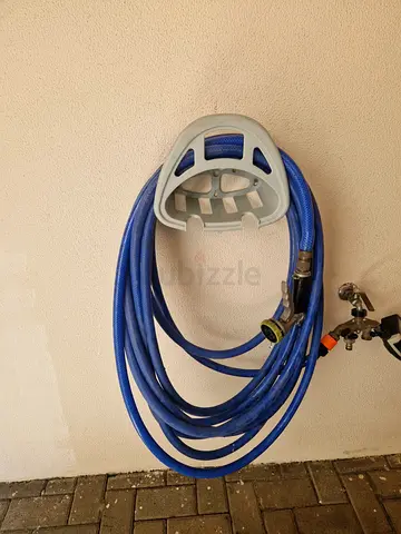 Used heavy-duty garden hose with wall-mount holder (blue) - good condition