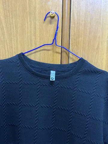 Black textured crew-neck sweater, size tag visible