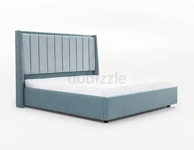 Light blue upholstered queen bed with padded headboard